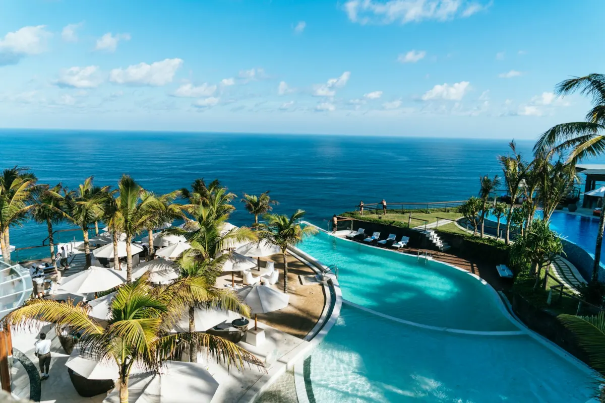 Infinity pool Elevee dengan pohon palem dan pemandangan laut